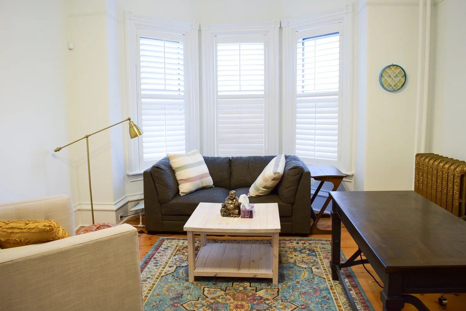 The Zen Room at Lotus Counselling Services, a calm office with a navy Lotus-logo accent wall, blue chairs, leafy plants, and a bay window